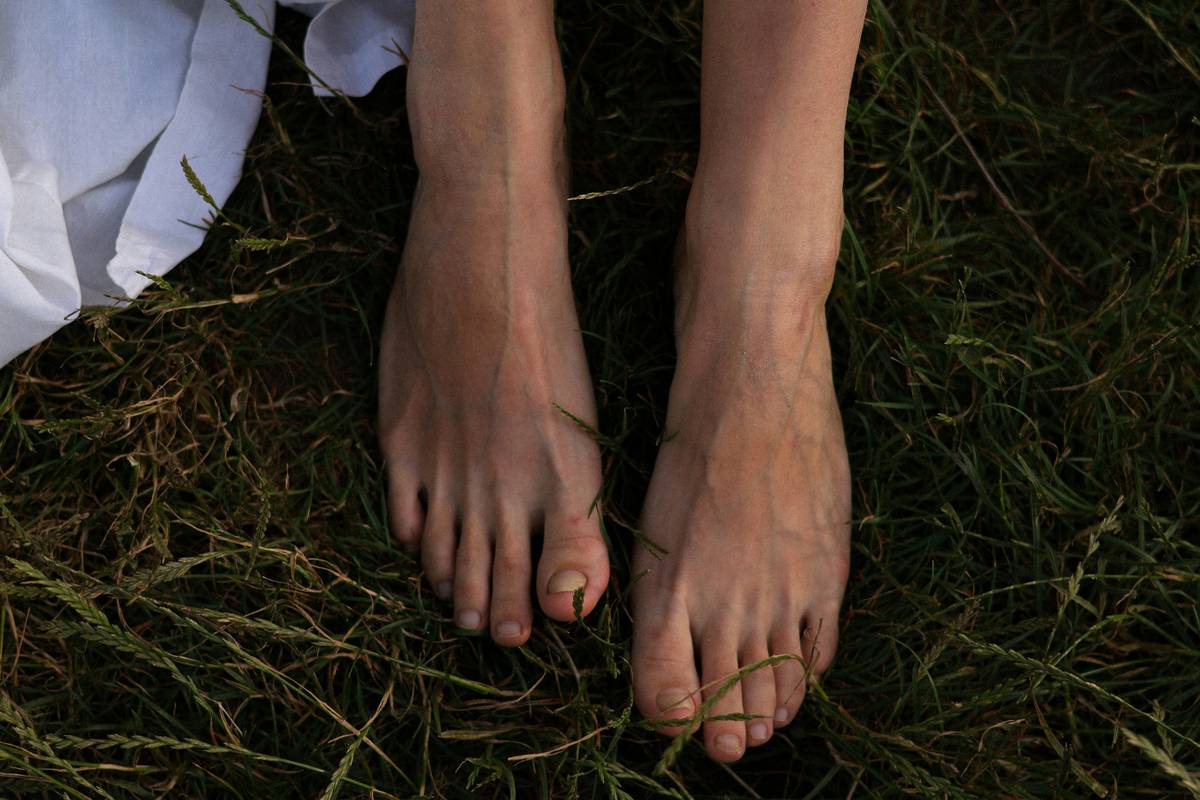 fresh feet foot scrubber lying beside pumice stone and moisturizer on a bamboo tray